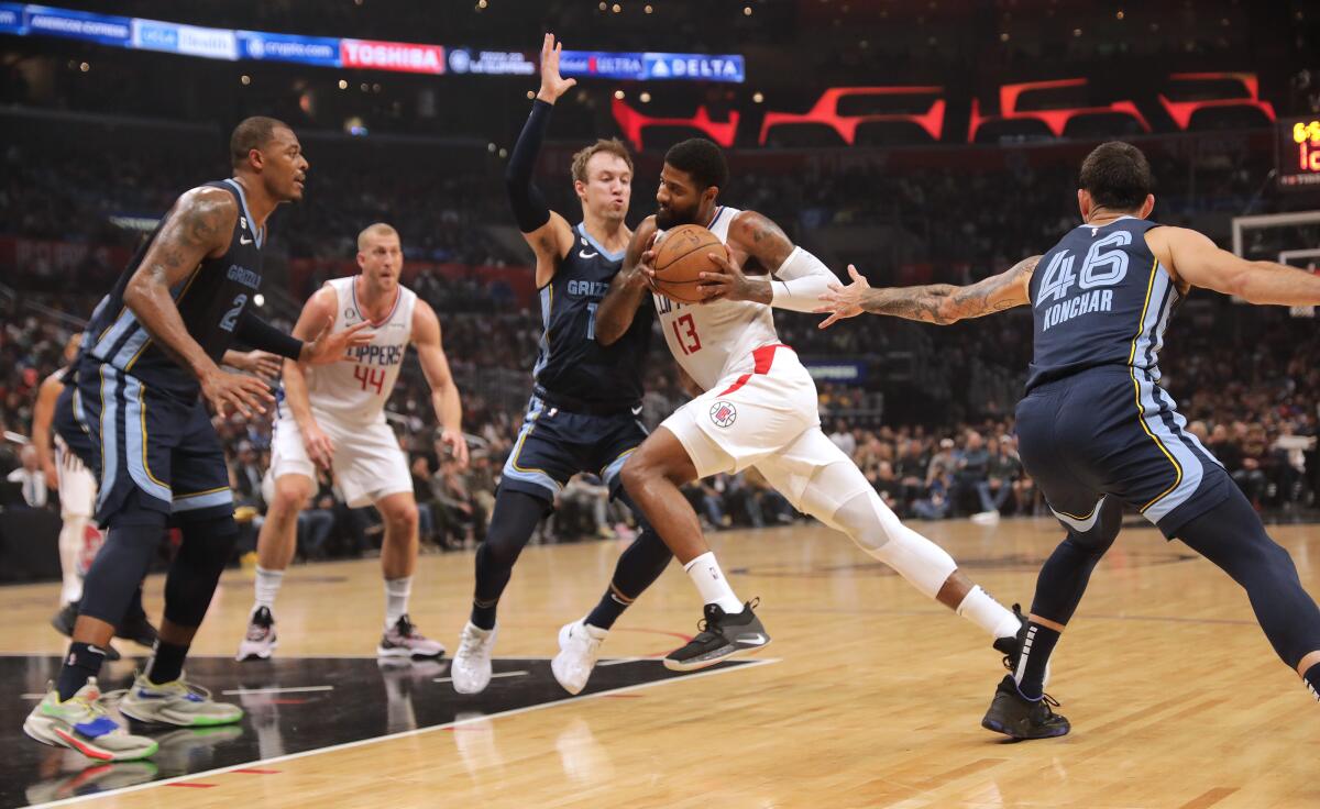 Clippers guard Paul George drives past Memphis Grizzlies forward Luke Kennard.