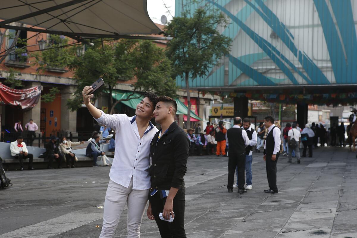 Dos jóvenes se toman una selfie en la Plaza Garibaldi de la Ciudad de México. 