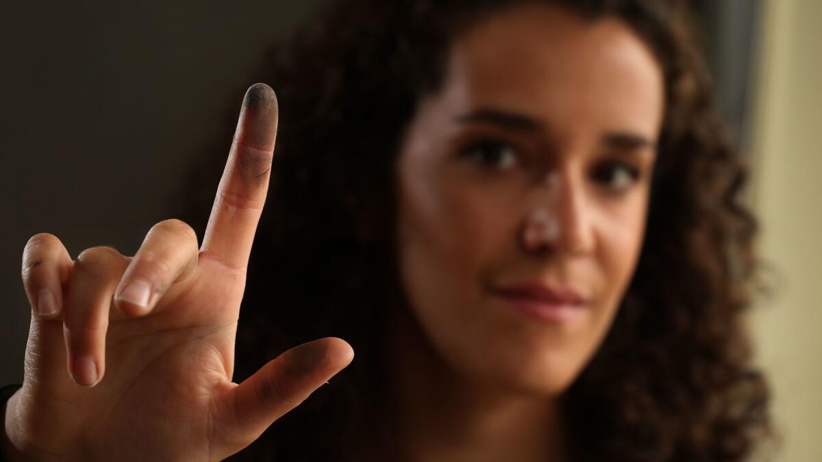 Amelia Mueller-Williams displays a finger with soot she removed from the windowsill of her apartment close to the 405 Freeway in West L.A.