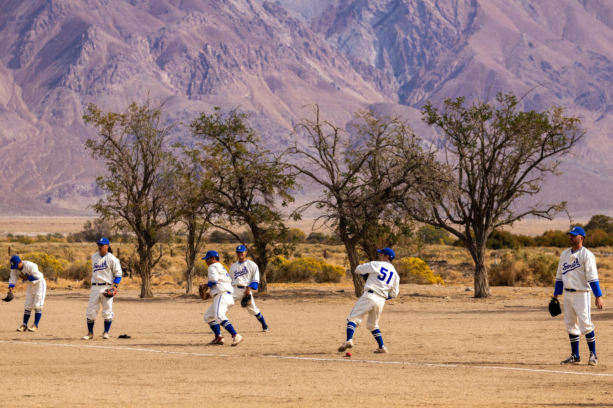 As Shohei Ohtani takes heart stage, remembering baseball at Manzanar jail camp 5 Players warm up before Saturday's game on the baseball field at Manzanar, restored to its wartime configuration.