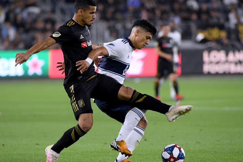LOS ANGELES, CALIFORNIA - JULY 06: Fredy Montero #12 of Vancouver Whitecaps keeps Mohamed El-Munir #13 of Los Angeles FC from the ball during a 6-1 LAFC win at Banc of California Stadium on July 06, 2019 in Los Angeles, California. (Photo by Harry How/Getty Images)