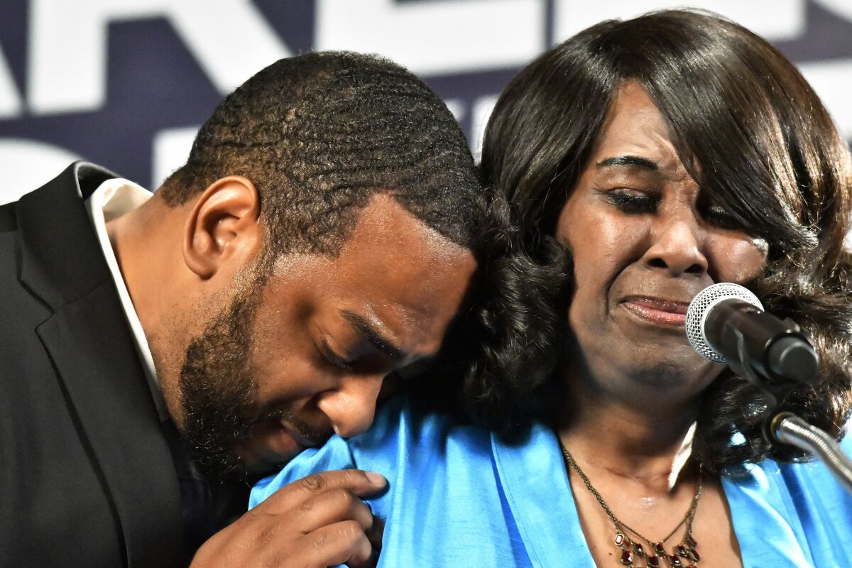 Democrat Charles Booker, left, hugs his mother, Earletta Hearn, as she speaks to a group of supporters following her son's victory in the Kentucky primary in Louisville, Ky., Tuesday, May 17, 2022. (AP Photo/Timothy D. Easley)