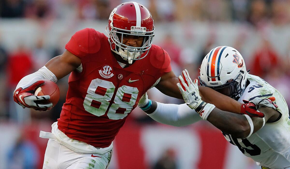 Alabama's O.J. Howard, left, attempts to evade Auburn's Tre' Williams during a game Saturday.