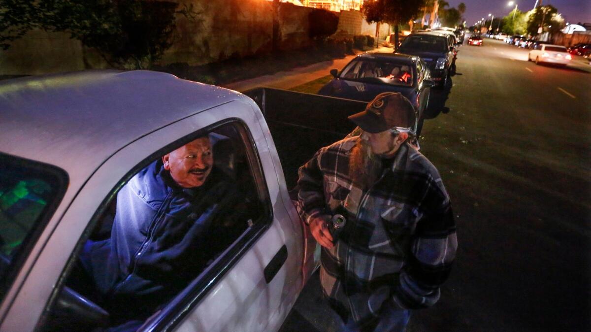 Workers line up on the street to find out if they'll get a shift at the ports. This ritual is repeated every morning for casual longshoremen and women. (Mark Boster / Los Angeles Times)