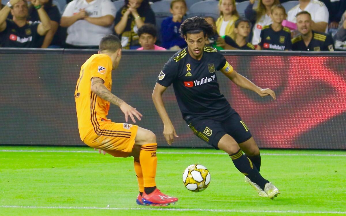 LAFC captain Carlos Vela dekes Houston Dynamo midfielder Matias Vera.