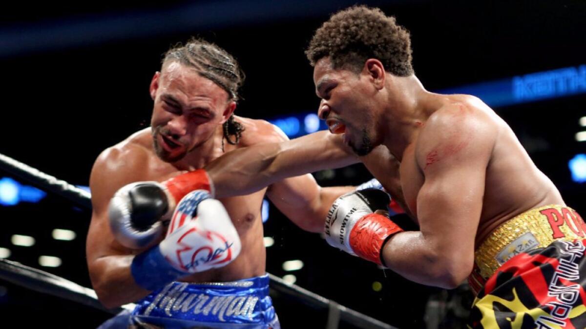 Keith Thurman crosses Shawn Porter's face with a right hand during their 12-round welterweight title bout on June 25.