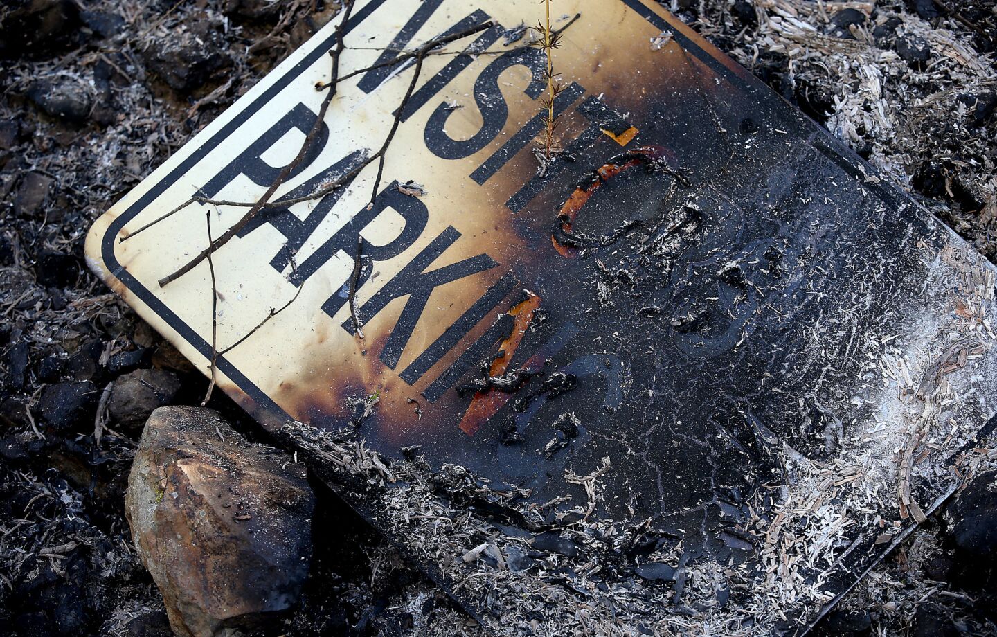 A charred sign sits beside a driveway in San Marcos, where the Cocos fire continues to burn.