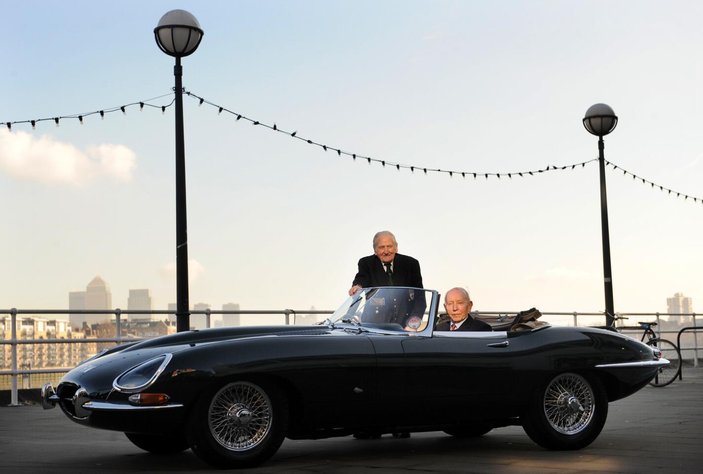 Former Jaguar E-Type test driver Norman Dewis, left, and former Formula One racing world champion John Surtees pose with a 1961 E-Type 77 RW Jaguar at the Design Museum in London.