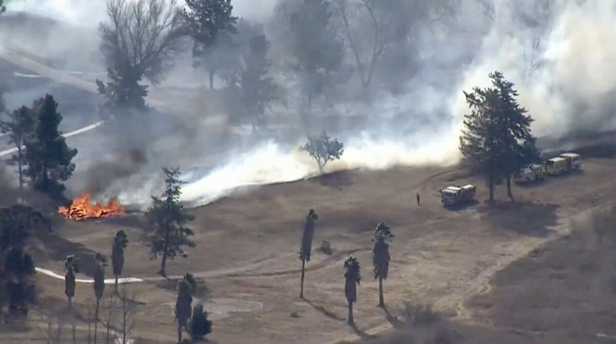 A brush fire burns, giving off a lot of smoke