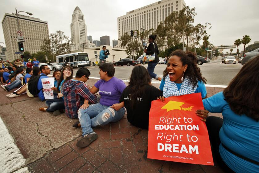 Baola Martinez 24, right, from the Dominican Republic joined more than 150 students and Dream Act supporters that rallied in front of the Federal Office Building in downtown Los Angeles on Friday June 15, 2012 to voice their support for President Obama's decision to halt the deportation of young illegal immigrants and form a human chain to block Aliso Street and the entrance to the southbound 101 Freeway at Los Angeles and Aliso streets. Martinez is a College student in New York City. (Al Seib / Los Angeles Times)