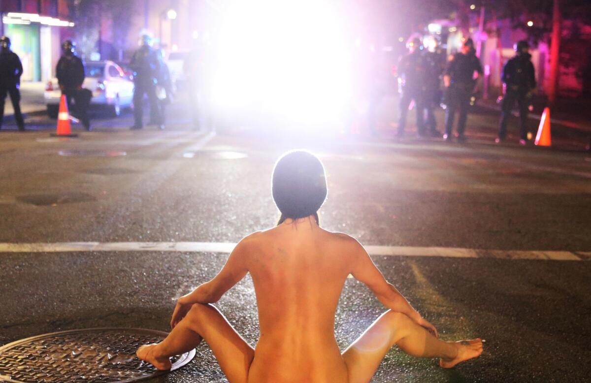 An unidentified naked woman faces Portland officers