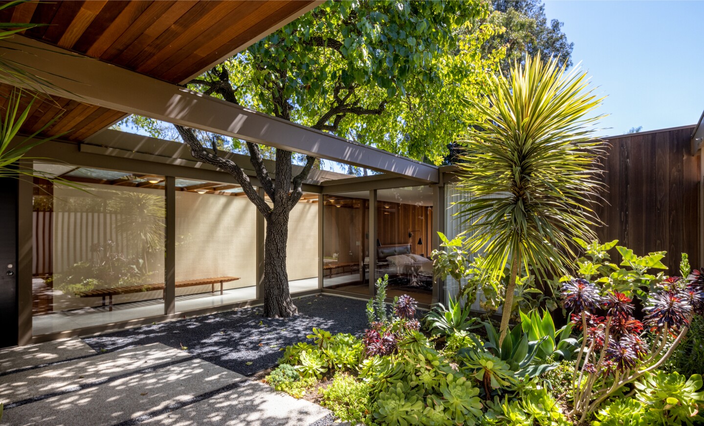 Built in 1961, the single-story home features Midcentury charms such as a courtyard entry, sky-lit hallways and warm wood-and-glass living spaces.