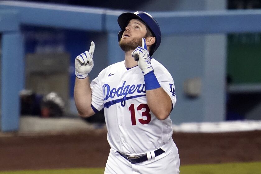 Los Angeles Dodgers' Max Muncy points as he nears home plate after his two-run home run.