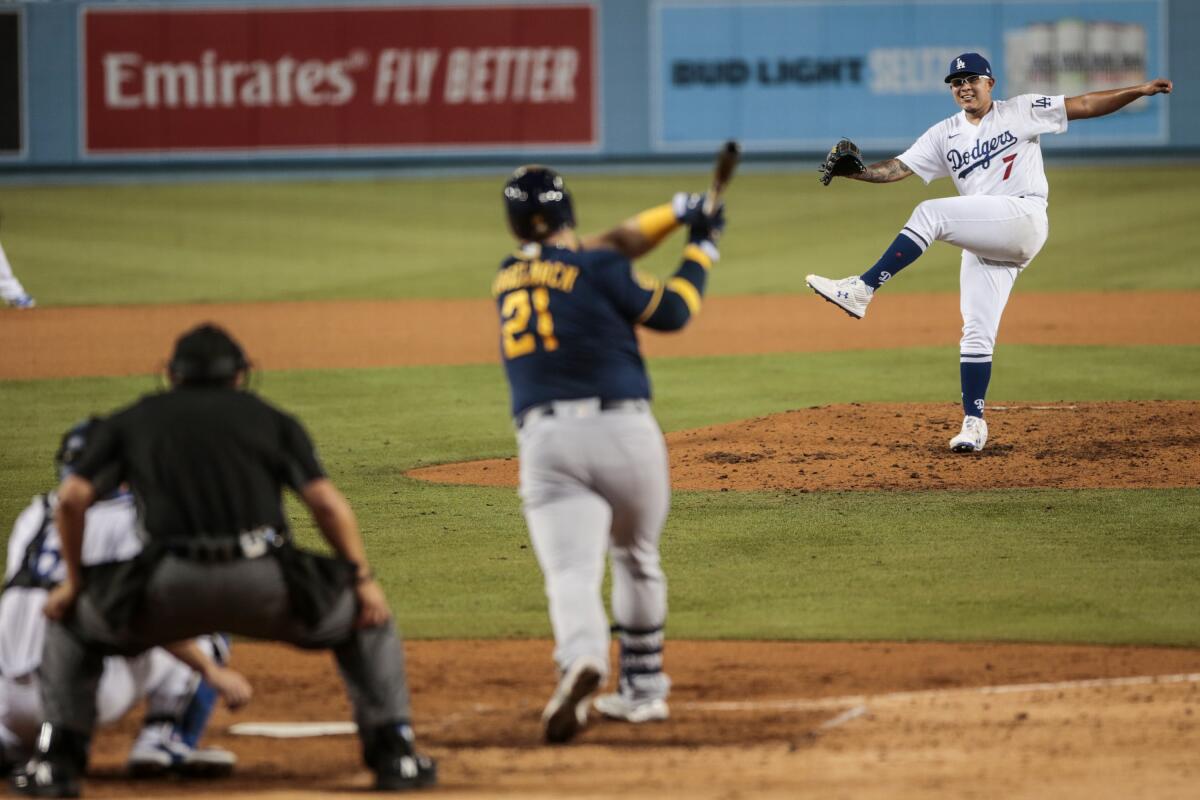 Julio Urias completes a pitch and Brewers first baseman Daniel Vogelbach swings and misses.