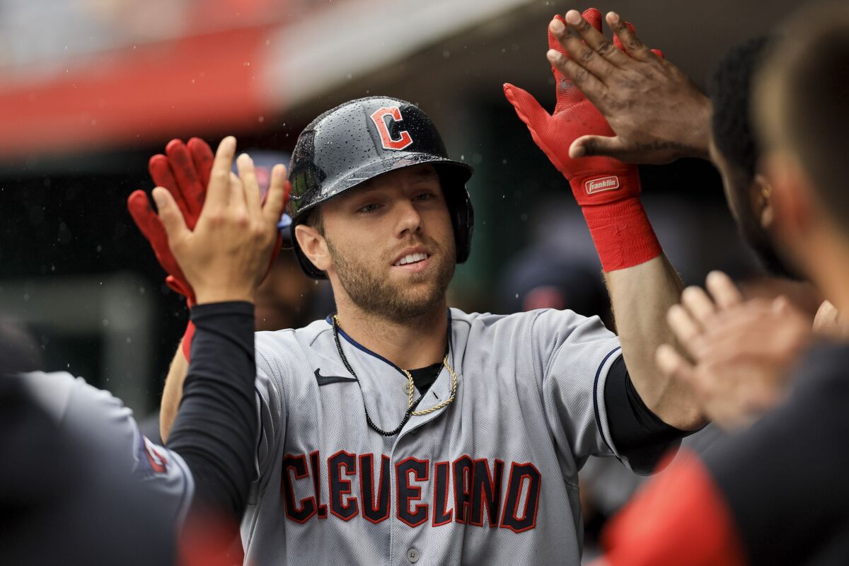 Cleveland Guardians' Owen Miller high-fives teammates after hitting a solo home run during the eighth inning of a baseball game against the Cincinnati Reds in Cincinnati, Wednesday, April 13, 2022. The Guardians won 7-3. (AP Photo/Aaron Doster)