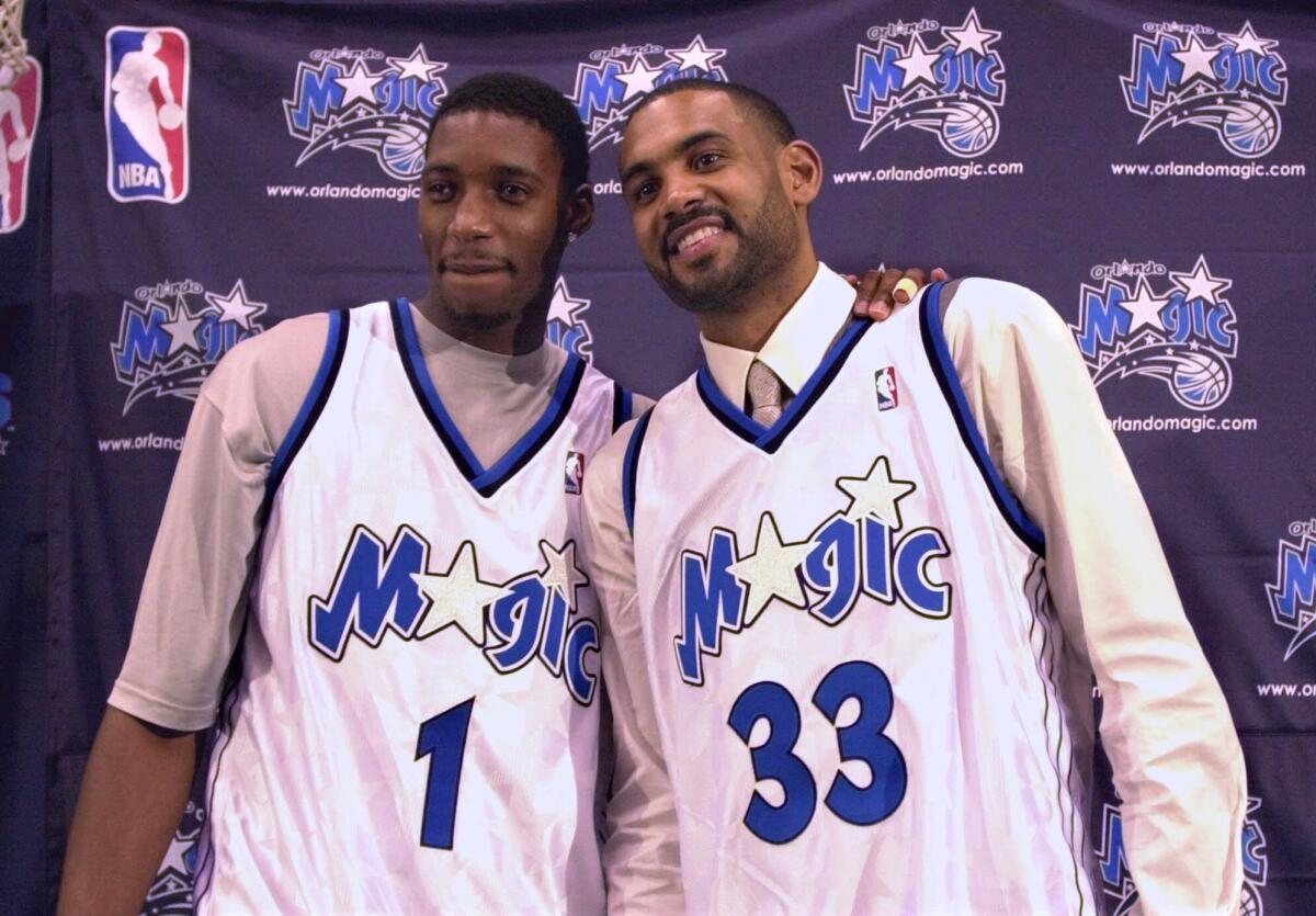 Tracy McGrady, left, and Grant Hill smile after being introduced as the newest members of the Orlando Magic in August 2000.