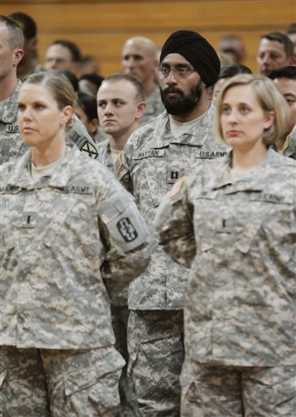 U.S. Army Capt. Tejdeep Singh Rattan, center wearing turban, stands with other graduates during a U.S. Army officer basic training graduation ceremony at Fort Sam Houston in San Antonio on Monday, March 22, 2010. Capt. Rattan is the first Sikh allowed to complete officer basic training while wearing the traditional turban and full beard since the Army altered the dress code, which had made exceptions for Sikh soldiers, in 1984. (AP Photo/Darren Abate)