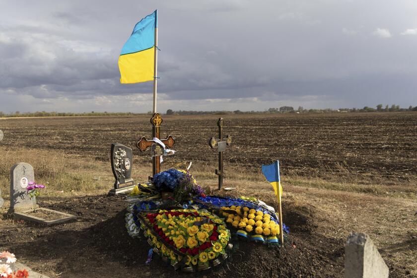 The grave of Ukrainian soldier Andrii Kozyr, who was reburied the day before, in the village of Hroza near Kharkiv, Ukraine, Friday, Oct. 6, 2023. The Russian rocket hit a cafe where friends and relatives gathered for the wake for Kozyr, killing at least 51 civilians in one of the deadliest attacks in recent months. (AP Photo/Alex Babenko)