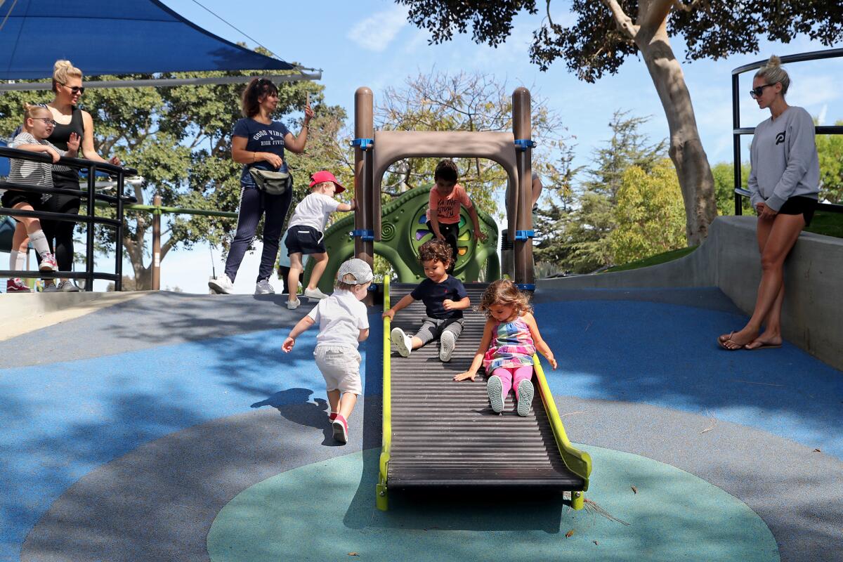 Children play along a slide at the newly renovated playground at Grant Howald Park in Corona del Mar.