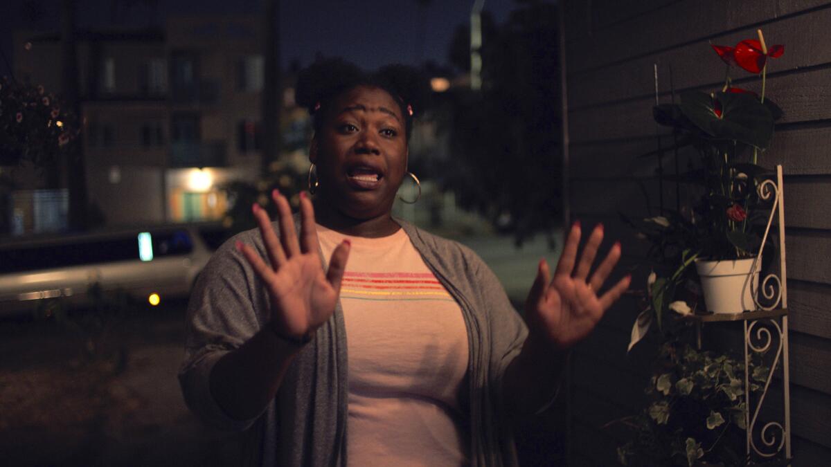 A woman holds up her hands in a nighttime photo. 