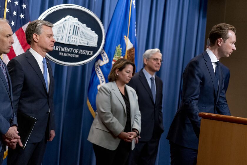 Justice Department's Klepto Capture Task Force Director Andrew Adams, right, accompanied by from left, Justice Department's Assistant Attorney General for the National Security Division Matthew Olsen, FBI Director Christopher Wray, Deputy Attorney General Lisa Monaco, and Attorney General Merrick Garland, speaks at a news conference at the Justice Department in Washington, Wednesday, April 6, 2022, to discuss new and recent enforcement actions to disrupt and prosecute criminal Russian activity. (AP Photo/Andrew Harnik)
