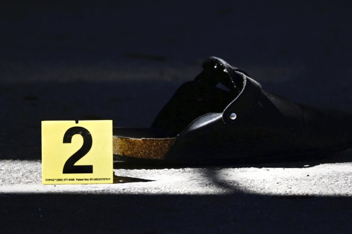 A shoe lies on the ground at the scene of a shooting in Ontario, Calif., on Saturday, Oct. 1, 2022, after a person was shot several times at a youth football game at Colony High School. The game was not a school-sponsored event. (Watchara Phomicinda/The Orange County Register via AP)