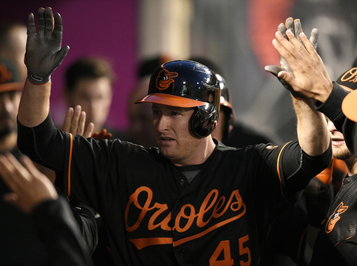 Orioles outfielder and Orange County native Mark Trumbo celebrates with his teammates after hitting a two-run home run during a game last season at Angel Stadium.