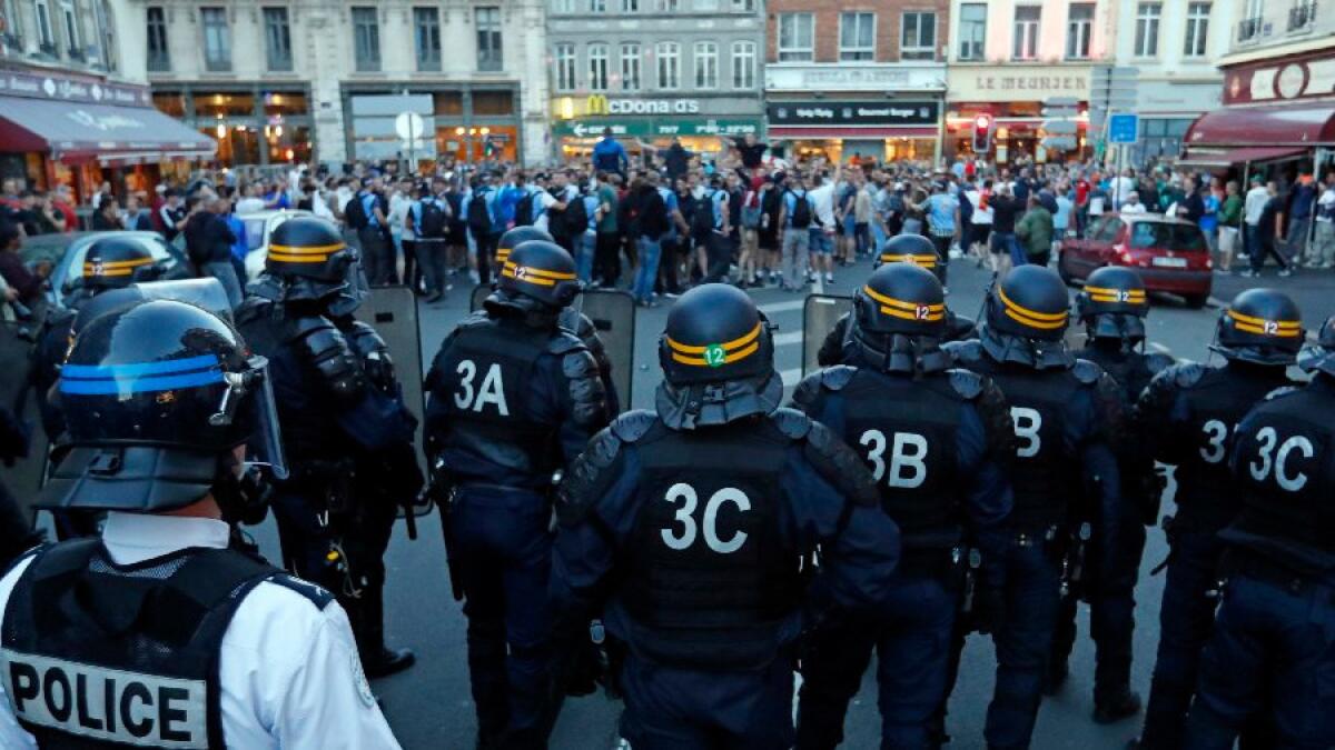 A group of England supporters gesture toward a line of police officers in downtown Lille, France, on June 15.