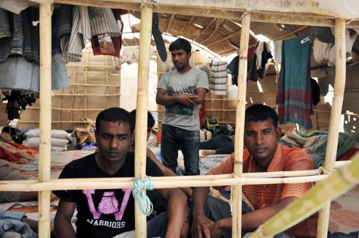 Migrant workers sit inside a makeshift camp in Manolada, Greece.