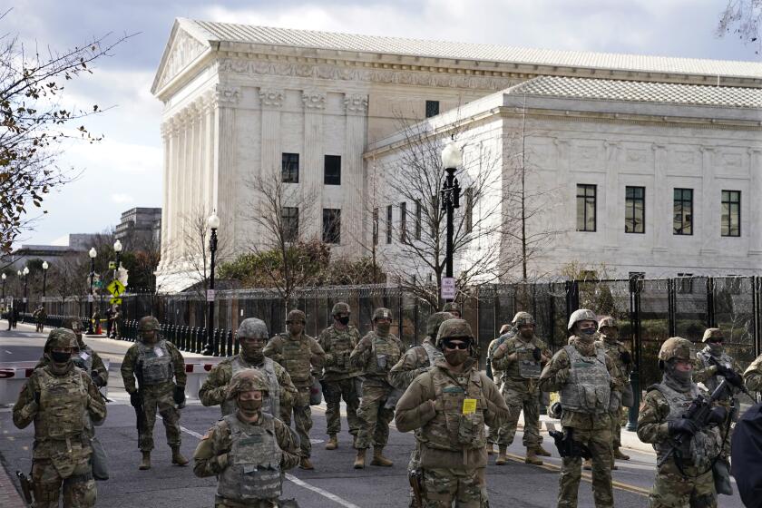 Members of the National Guard stand at a road block near the Supreme Court ahead of President-elect Joe Biden's inauguration ceremony, Wednesday, Jan. 20, 2021, in Washington. (AP Photo/John Minchillo)