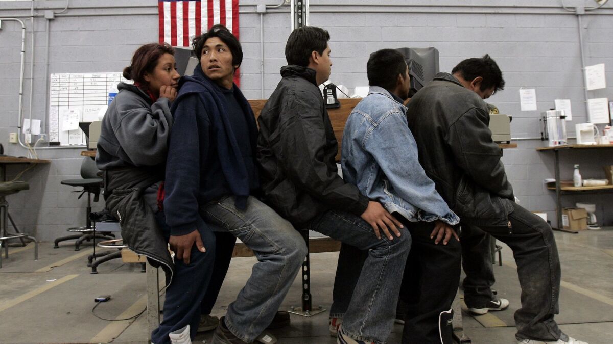 A group of migrants await processing in a U.S. Border Patrol detention center in Nogales, Arizona.