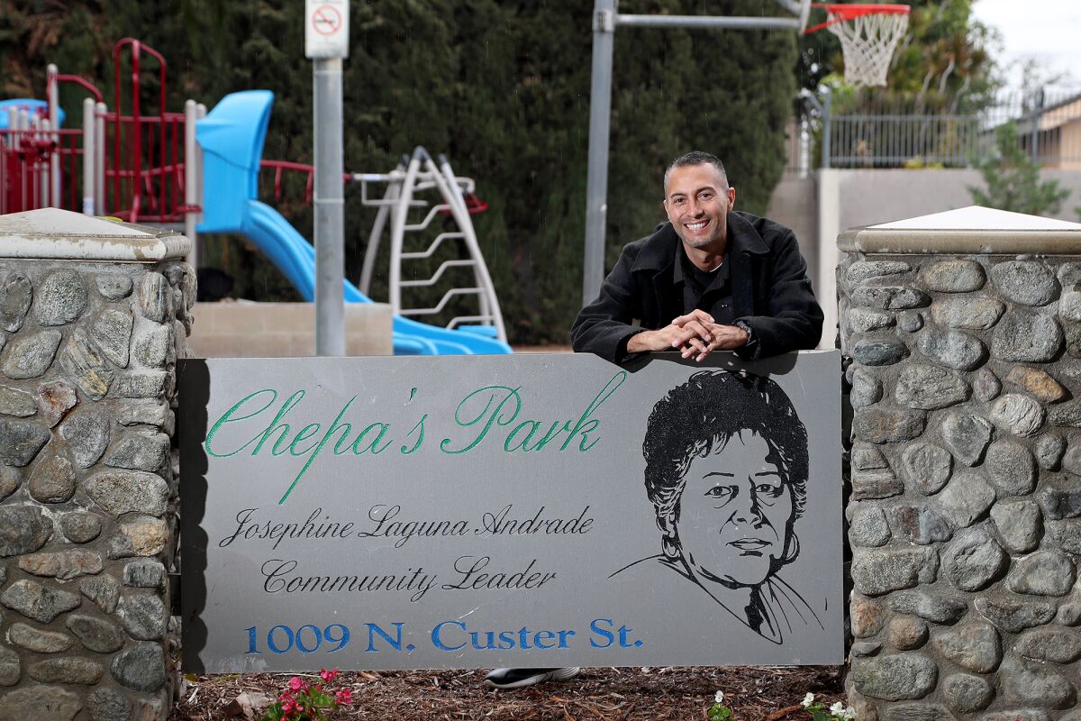 Michael Andrade leans on a sign etched with the likeness of grandmother, Josephine "Chepa" Andrade, at Chepa's Park. 