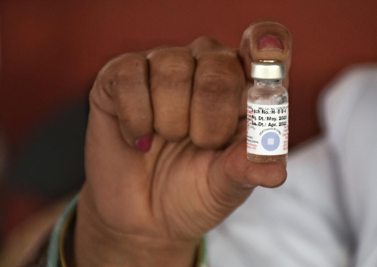 A health worker showing a vial of polio vaccine