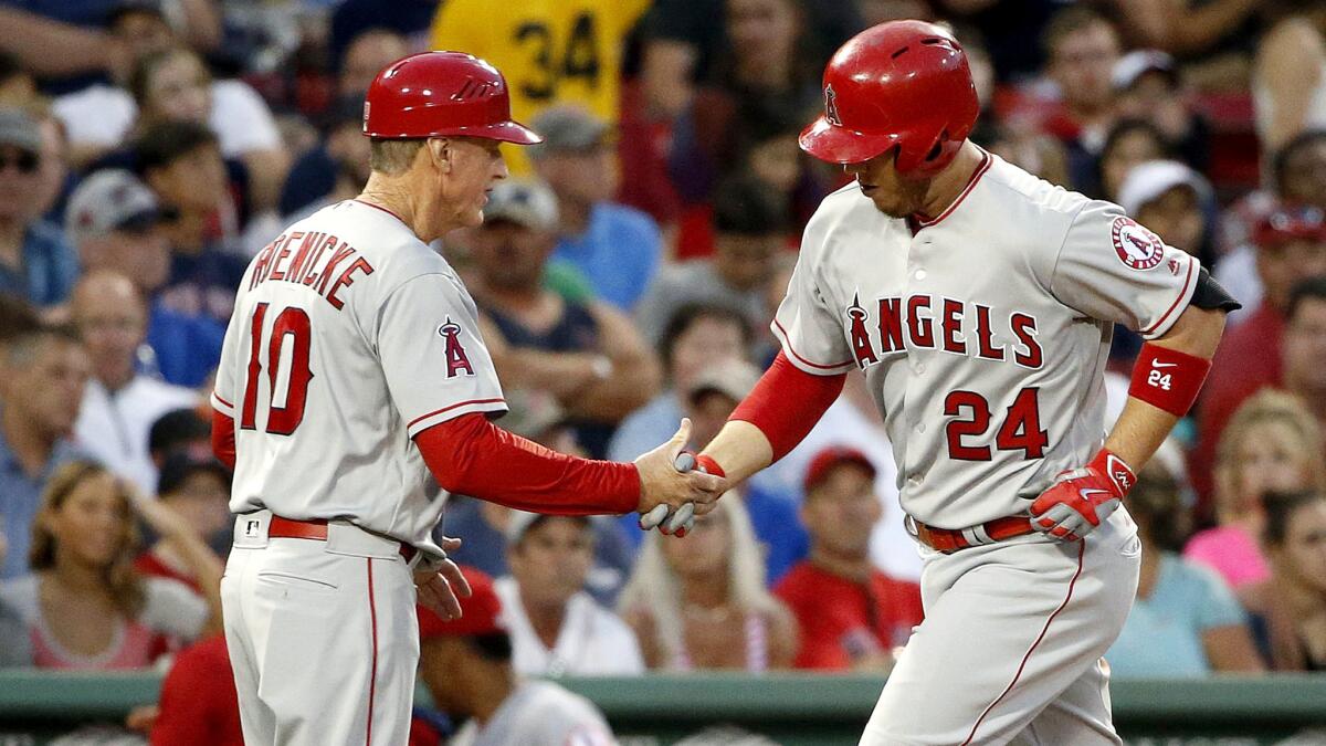 Angels first baseman C.J. Cron (24) is congratulated by third base coach Ron Roenicke after hitting a solo home run against the Red Sox during the fourth inning Saturday.