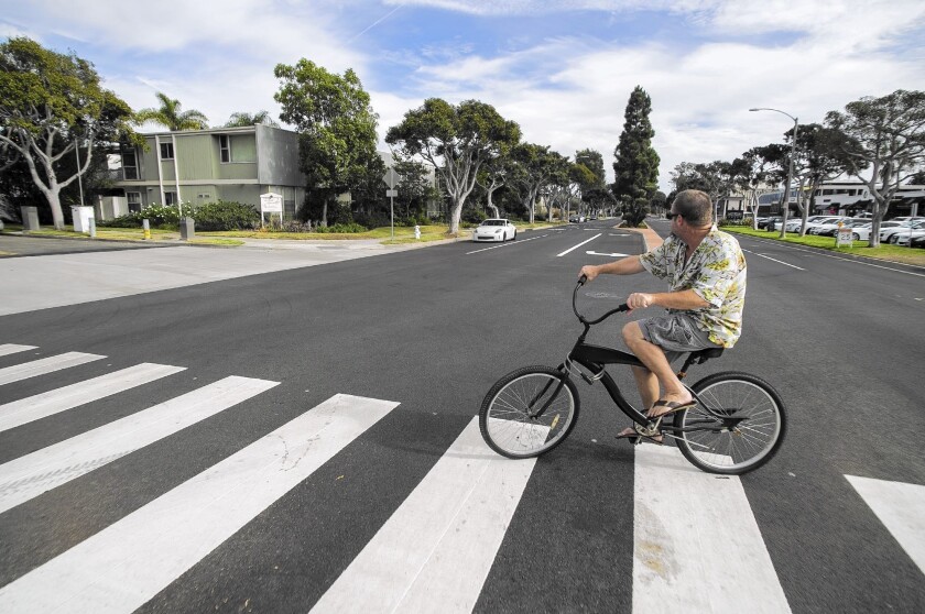 James Umholtz rides in a crosswalk on Westcliff Drive at Rutland Road on Tuesday. An online petition is calling for Newport Beach to embed flashing lights in the crosswalk as a safety measure after pedestrian Donald Fuschetti was struck and killed by an SUV there on Oct. 11.