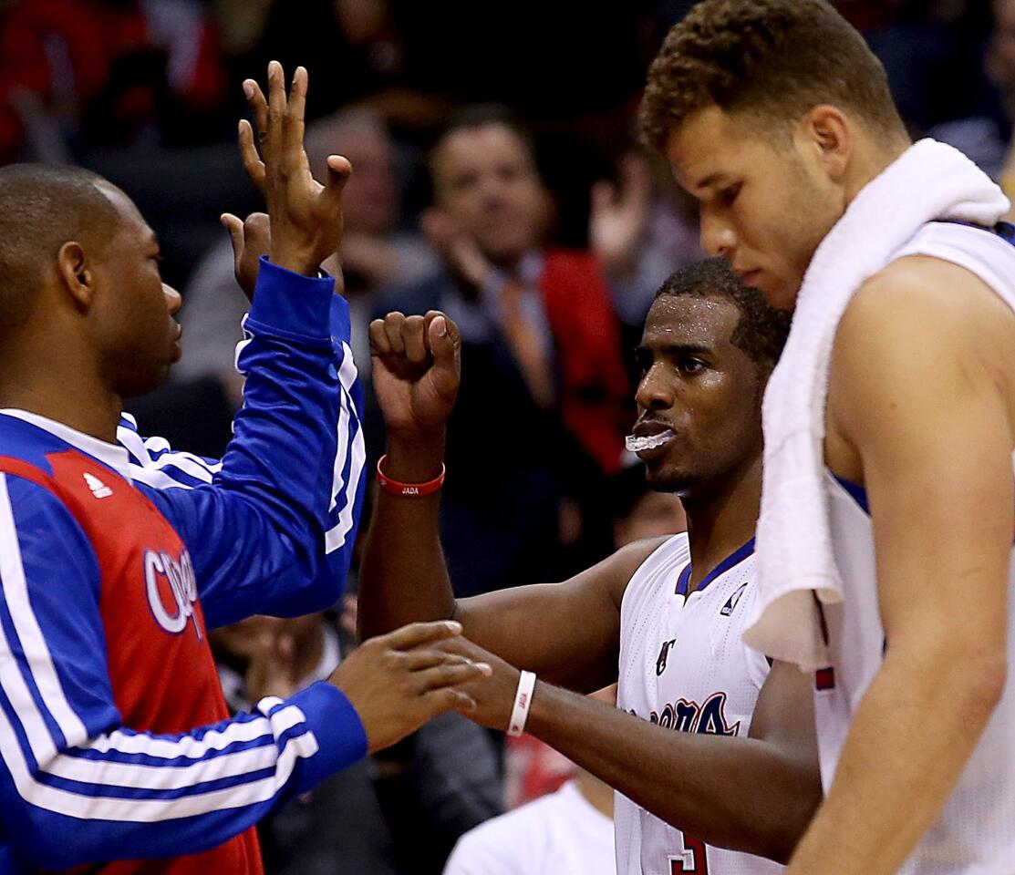 Clippers point guard Chris Paul, center, is congratulated by teammate Willie Green as he leaves the game against the Warriors in the fourth quarter with a victory secured.