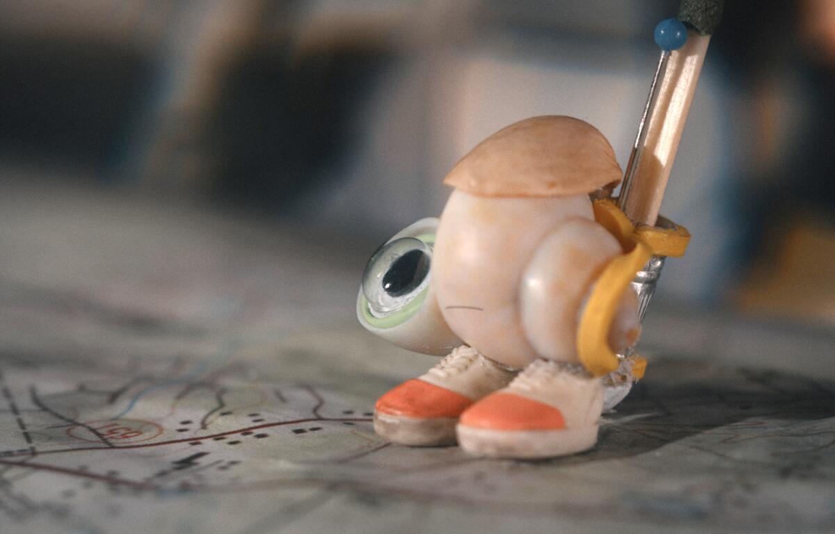 An image of a shell with an eye and shoes in the movie “Marcel the Shell With Shoes On.”