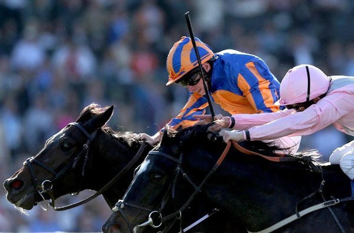 Magician and jockey Ryan Moore edge ahead of The Fugue and jockey William Buick for a victory in the Breeders' Cup Turf race on Saturday at Santa Anita Park.