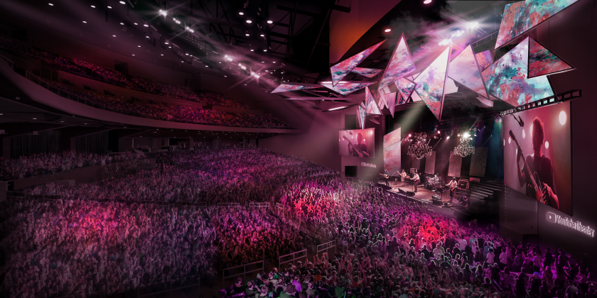 People fill seats and a band plays on a stage flanked by video screens in a rendering.