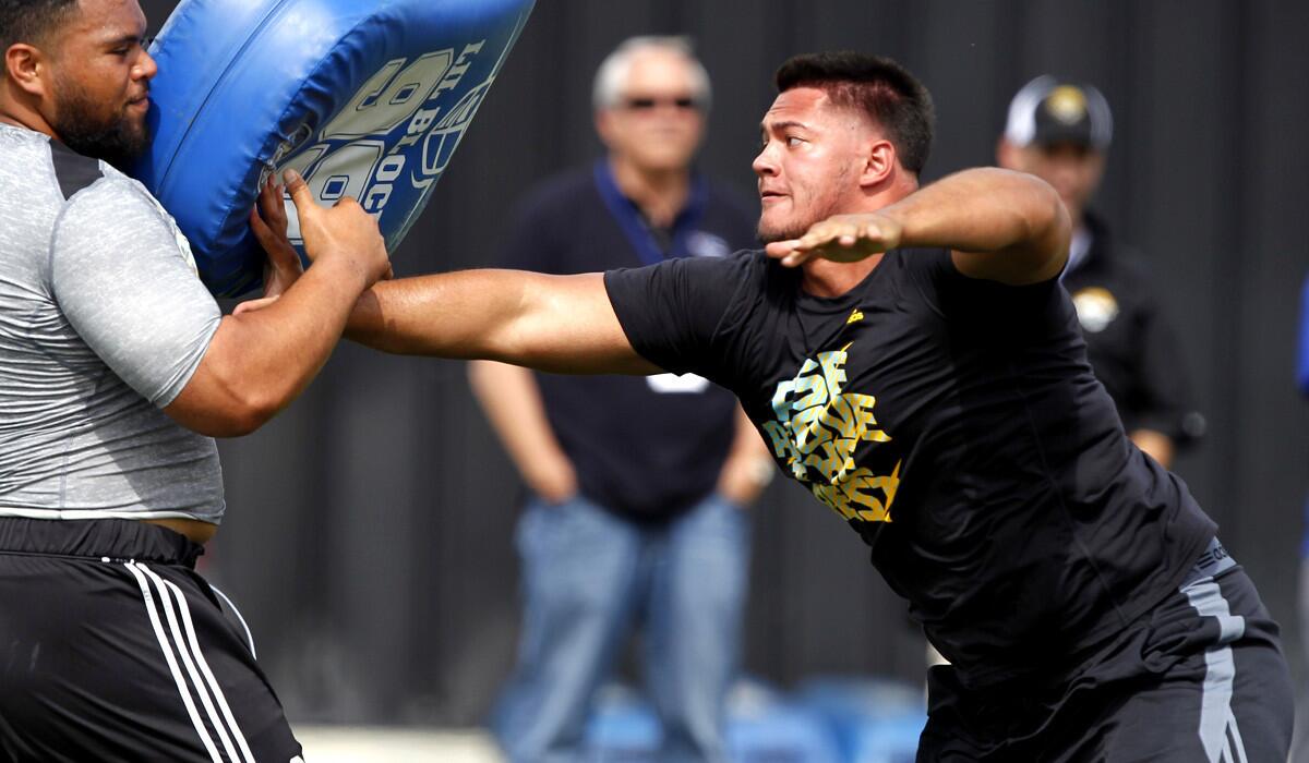 Xavier Su'a-Filo, right, works out with Sealii Epenesa during UCLA's pro day for NFL scouts.