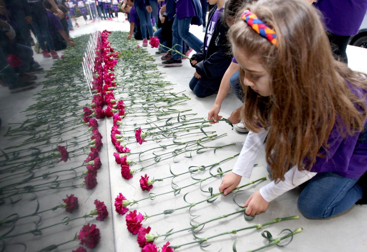Chamlian Armenian School second-grade students lay carnations during the annual Armenian Genocide Commemorative Walk to the Armenian Western Prelacy Headquarters in La Crescenta on Thursday, April 7, 2016. At the headquarters, the students laid down carnations at an Armenian Genocide Memorial.