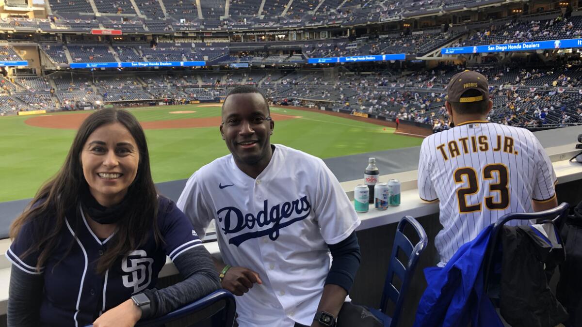 Fans wear uniforms of the Los Angeles Dodgers, left, and the Los