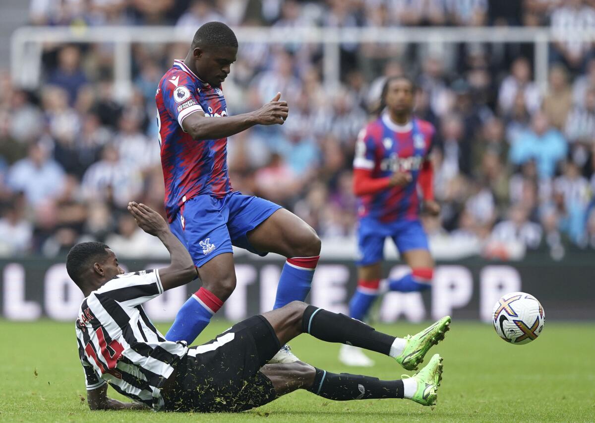 Newcastle United's Alexander Isak, below, challenges Crystal Palace's Cheick Doucoure during the English Premier League soccer match between Newcastle United and Crystal Palace at St. James' Park, Newcastle, Saturday, Sept. 3, 2022. (Owen Humphreys/PA via AP)
