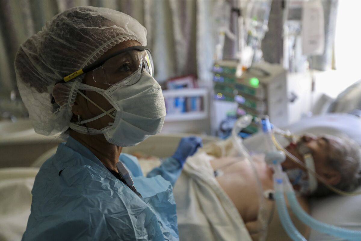 In July, nurse Jeanette Pimentel checks on a COVID-19 patient in intensive care at Paradise Valley Hospital in National City.
