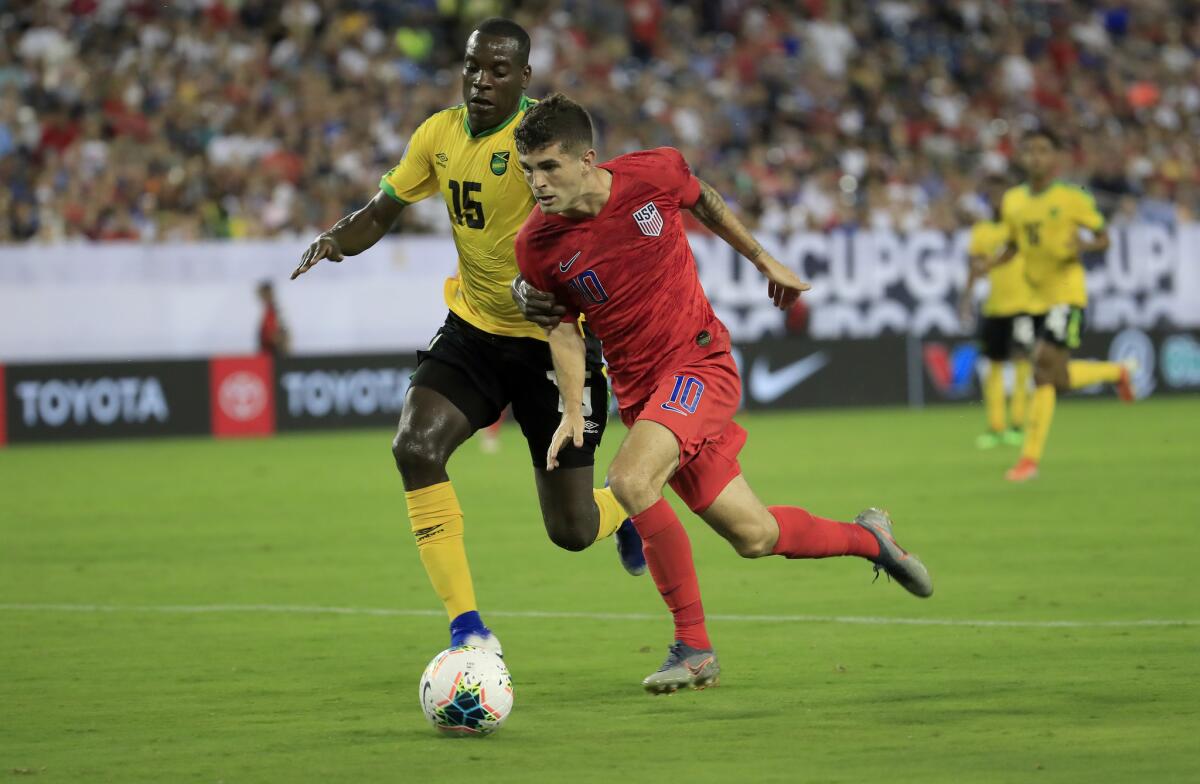 United States' Christian Pulisic (10) and Jamaica's Je-vaughn Watson (15) compete for the ball in the semifinal game of the Gold Cup on Wednesday in Nashville, Tenn.