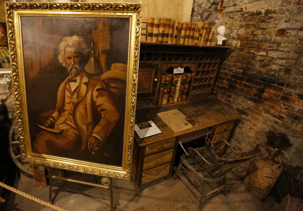 The Mark Twain Museum and Territorial Enterprise Office is in the basement of a store on C street in Virginia City. The desk possibly used by Twain is in the corner of the museum, with a portrait of the author on an easel. (Mark Boster / Los Angeles Times)