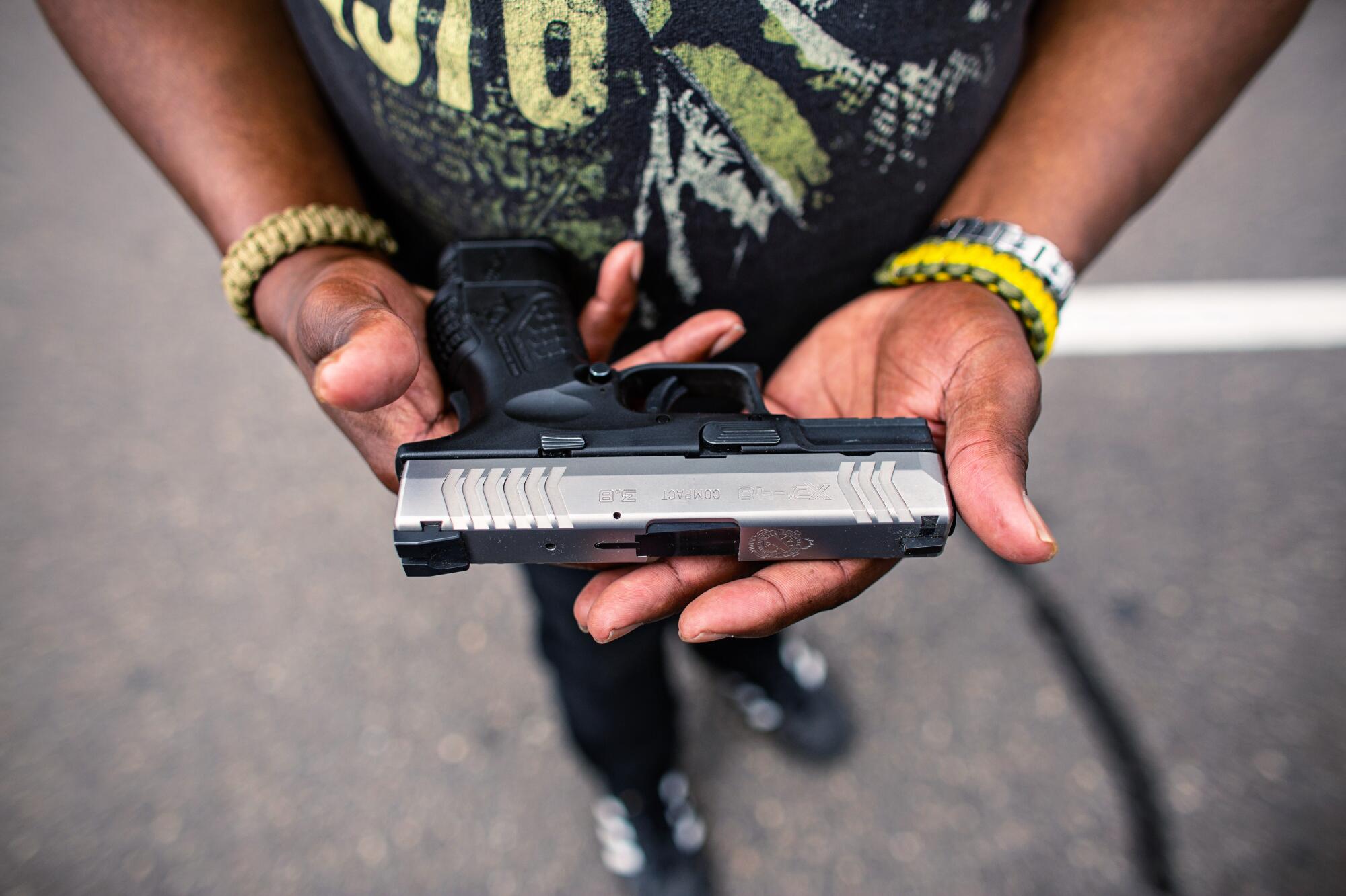 The Rev. Tim Christopher holds his pistol, which he always carries, at an event held by the Minnesota Freedom Fighters.