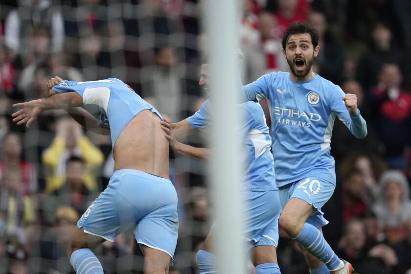 Manchester City's Rodrigo, left, runs to celebrate with teammates after scoring his sides second goal during the Premier League soccer match between Arsenal and Manchester City at the Emirates Stadium, in London, England, Saturday Jan. 1, 2022. (AP Photo/Matt Dunham)