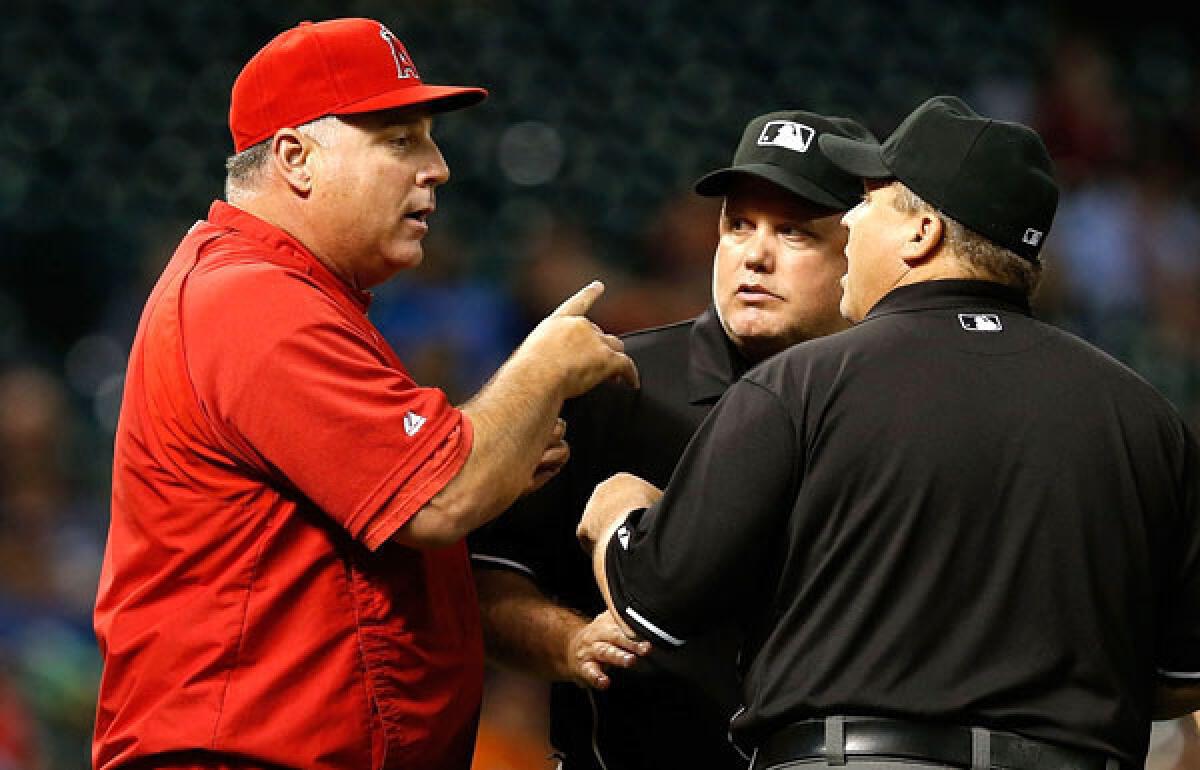 Angels Manager Mike Scioscia argues with umpires about a pitching change the Astros made in the seventh inning on Thursday night at Minute Maid Park in Houston.