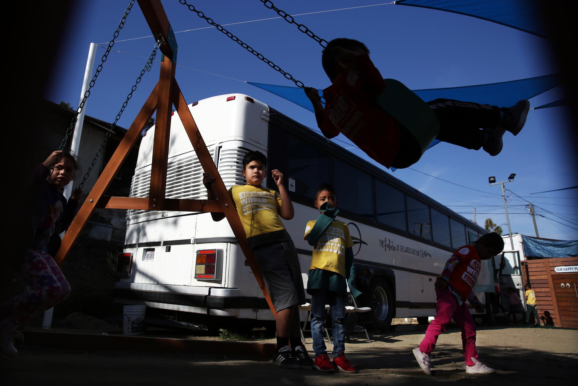 Students play after class. The Yes We Can foundation cleaned up the property near the bus to serve as a playground.